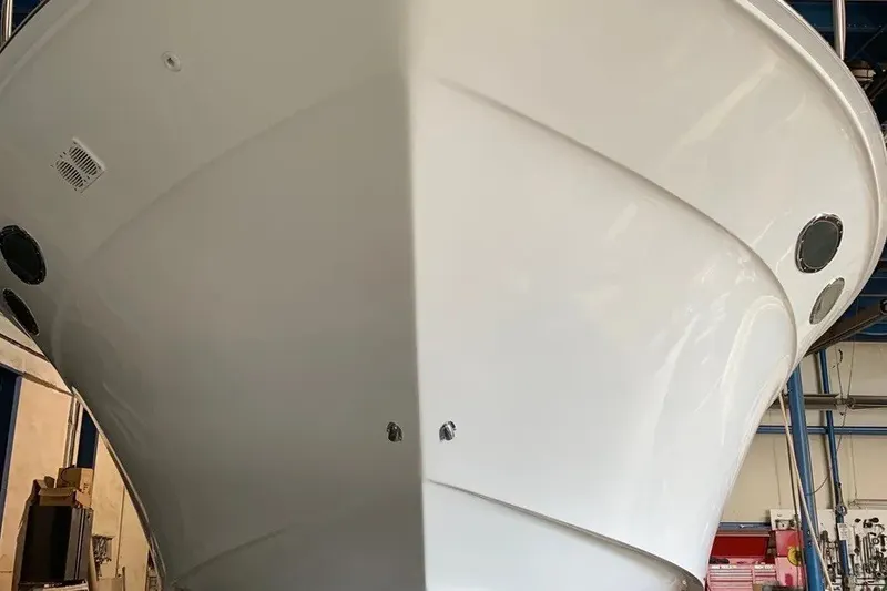 Slide: The Image of 1998 Sea Ray 370 Express Cruiser in a workshop, showcasing its sleek white hull. - 11