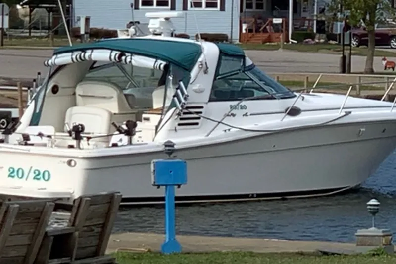 Slide: The Image of 1998 Sea Ray 370 Express Cruiser docked at a marina with teal canopy. - 3