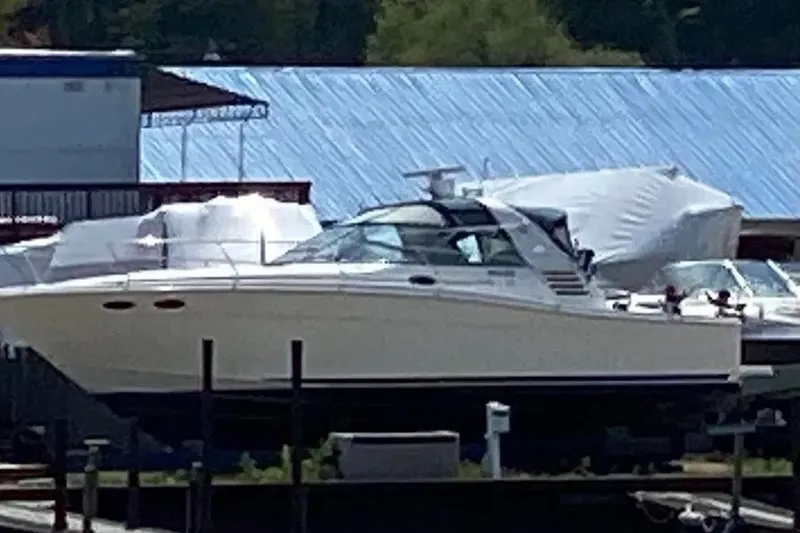 Slide: The Image of 1998 Sea Ray 370 Express Cruiser docked at marina, covered boats in background. - 14