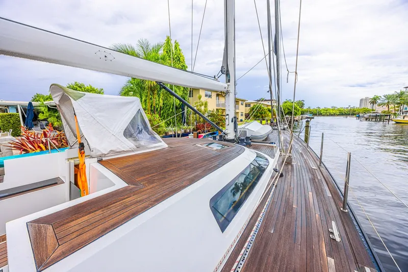 Slide: The Image of Luxurious 2007 CNB 70 yacht with sleek wooden deck, docked by a scenic waterfront. - 34