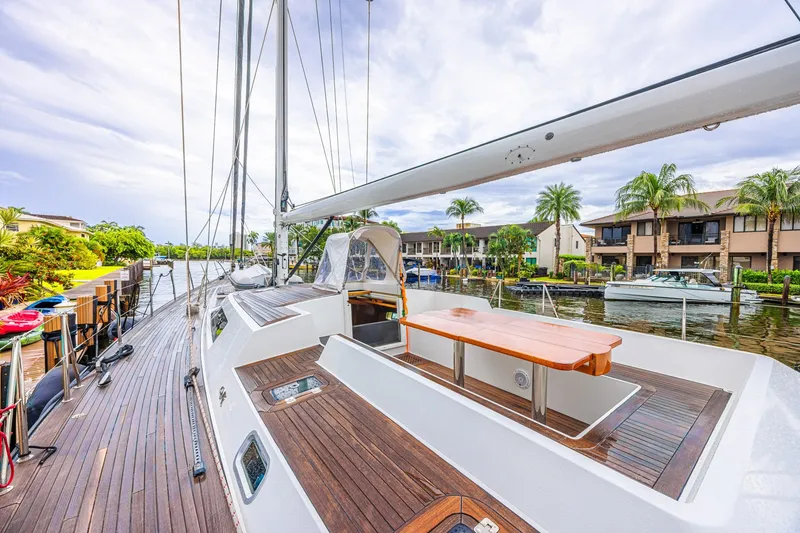 Slide: The Image of Luxurious 2007 CNB 70 yacht docked, featuring sleek wooden deck and scenic waterfront view. - 29