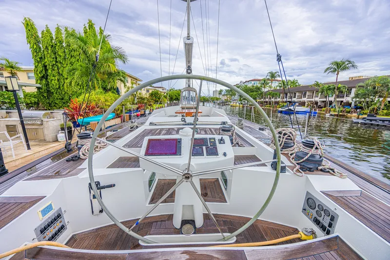Slide: The Image of Steering wheel of a 2007 CNB 70 yacht docked by a lush waterfront. - 18