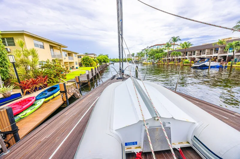 Slide: The Image of Sailboat docked in a scenic canal with colorful kayaks and waterfront homes, CNB 70, 2007. - 16