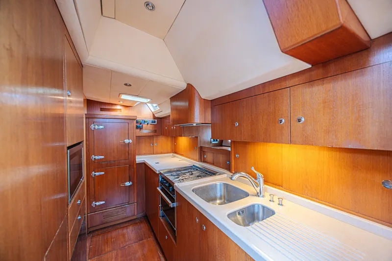 Slide: The Image of Luxurious wooden yacht kitchen interior, CNB 70 model, 2007, featuring modern appliances and ample storage. - 46