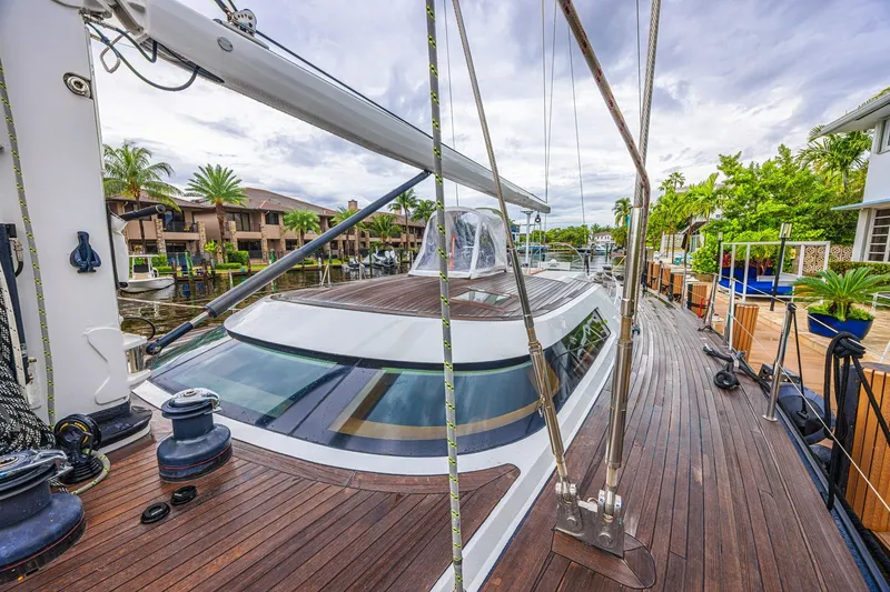 Slide: The Image of Luxurious 2007 CNB 70 yacht docked, showcasing sleek design and polished wooden deck. - 17