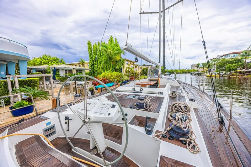 Slide: The Image of Luxurious 2007 CNB 70 yacht docked by a scenic waterfront with lush greenery. - 32