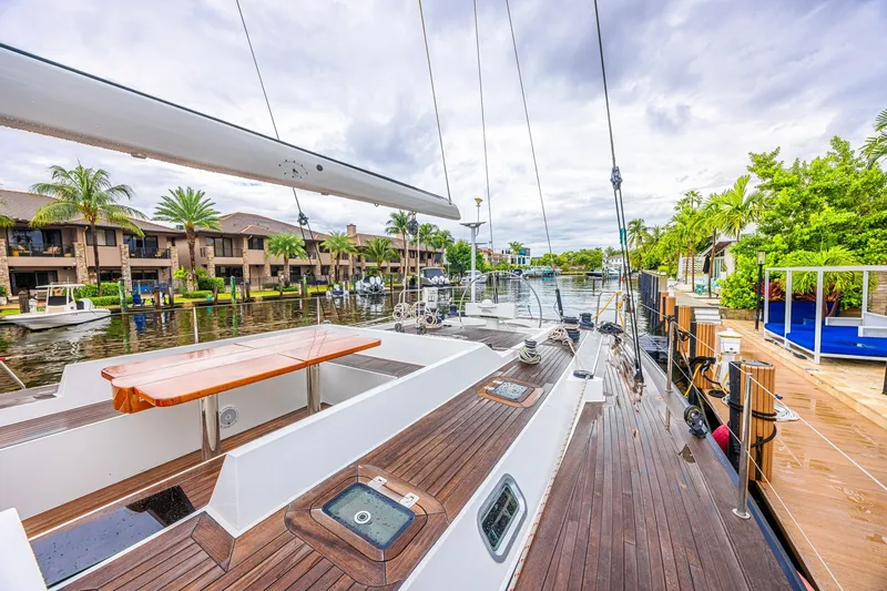 Slide: The Image of Luxurious 2007 CNB 70 yacht docked in a scenic waterfront setting with palm trees. - 26