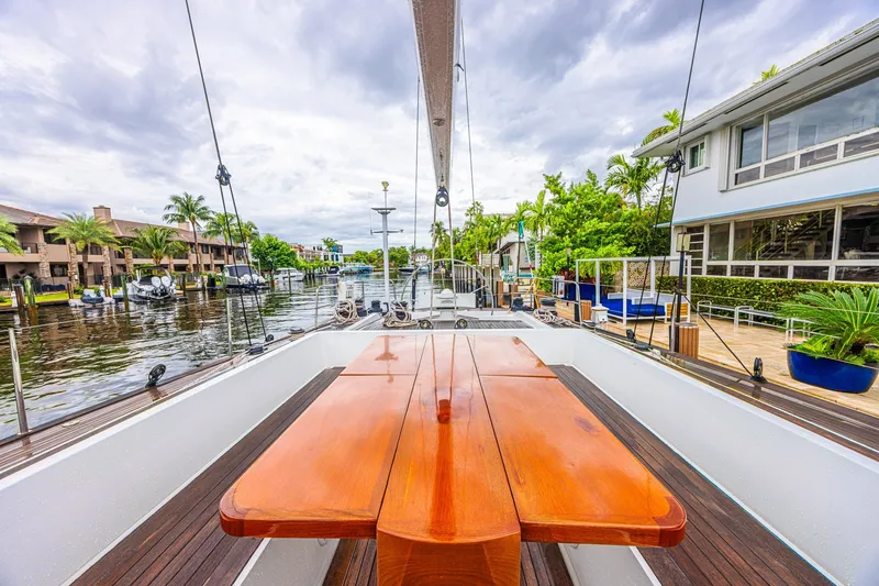 Slide: The Image of Luxurious CNB 70 yacht deck with wooden table, docked by waterfront homes, 2007 model. - 27