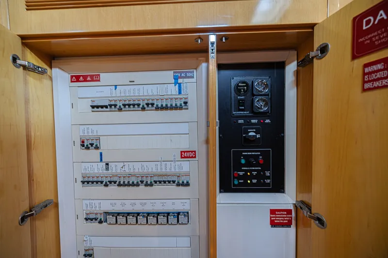 Slide: The Image of Electrical panel inside a 2007 CNB 70 yacht, featuring circuit breakers and control gauges. - 60