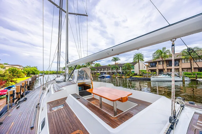 Slide: The Image of Luxurious 2007 CNB 70 yacht docked by waterfront homes, featuring elegant wooden deck. - 21