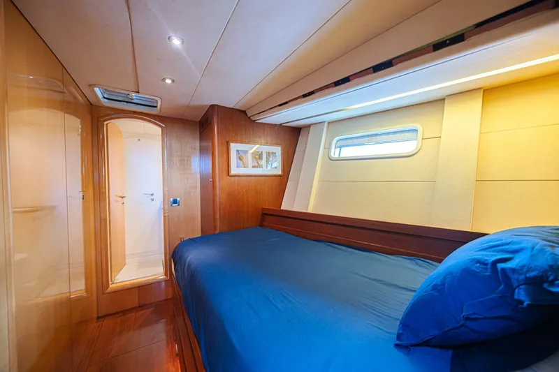 Slide: The Image of Luxurious cabin interior of 2007 CNB 70 yacht with blue bedding and wooden accents. - 55