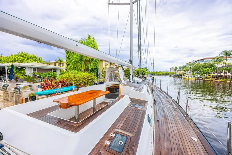 Slide: The Image of Luxurious 2007 CNB 70 yacht docked by a scenic waterfront with lush greenery. - 19
