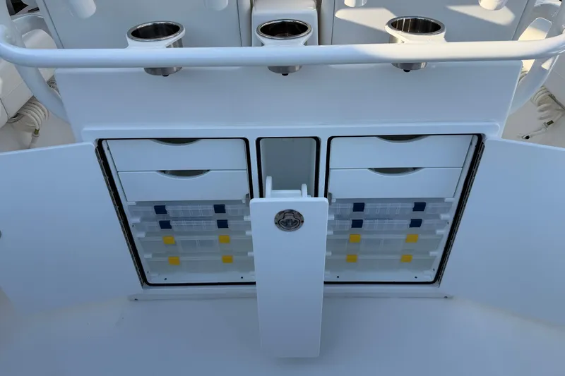 Slide: The Image of 2026 Regulator 28 boat storage compartments with organized tackle boxes and cup holders. - 31