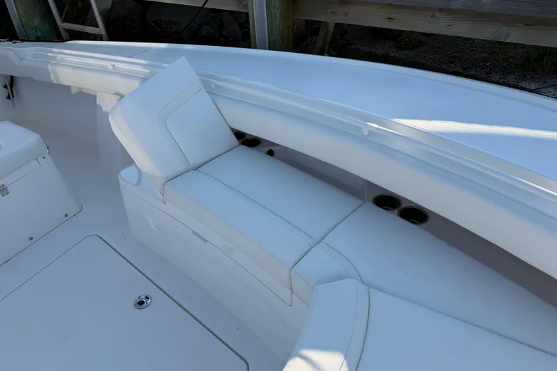 Slide: The Image of 2026 Regulator 28 boat interior with white cushioned seating and cup holders. - 56