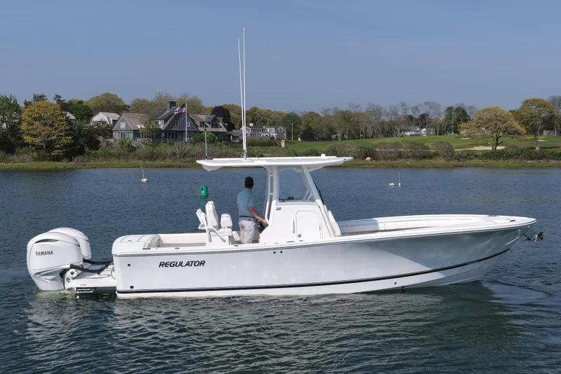The Image of 2026 Regulator 28 boat on calm water with scenic shoreline background. - 1