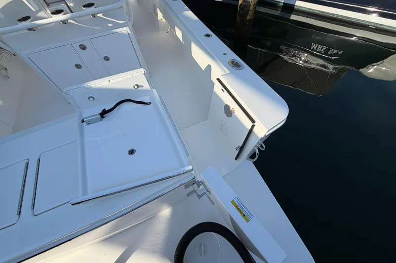 Slide: The Image of 2026 Regulator 28 boat deck with storage compartments and clean white finish. - 22