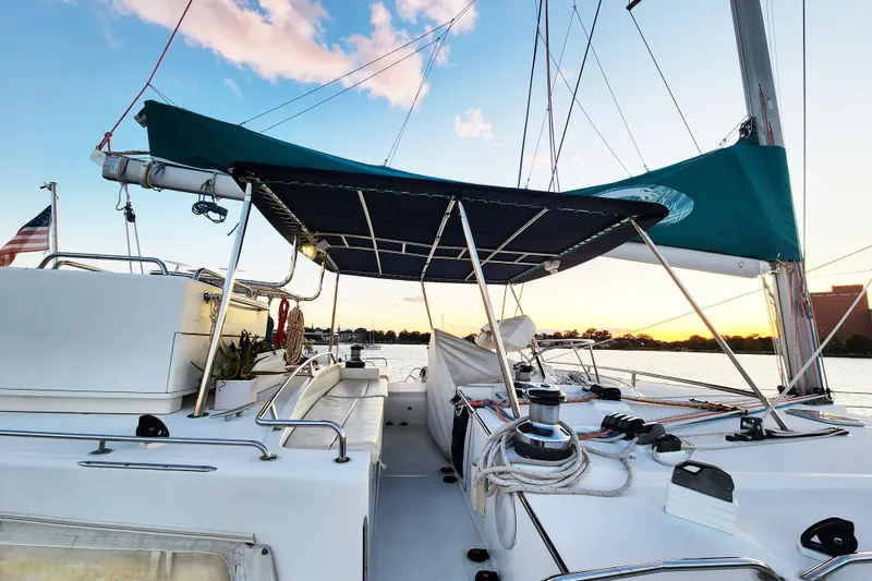 Slide: The Image of 2008 Lagoon 500 sailboat deck at sunset, featuring a spacious cockpit and canopy. - 17