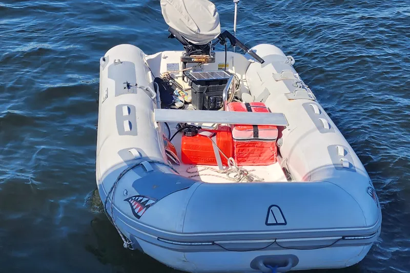 Slide: The Image of Inflatable boat on water with shark design, featuring equipment and storage. - 26