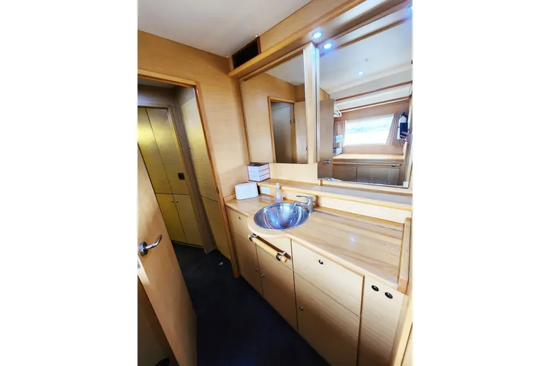 Slide: The Image of Interior of 2008 Lagoon 500 yacht bathroom with wooden cabinetry and modern sink. - 52
