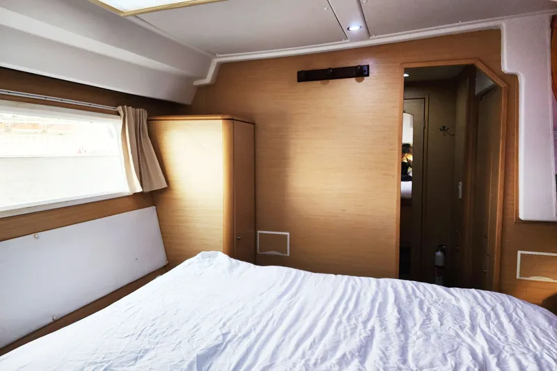 Slide: The Image of Interior cabin of a 2008 Lagoon 500 yacht with bed and window view. - 56