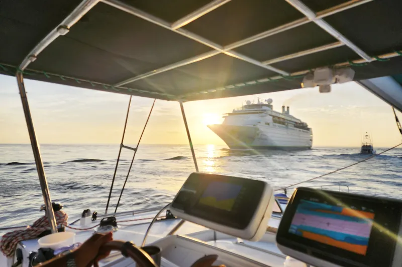 Slide: The Image of Sailing on a 2008 Lagoon 500 catamaran at sunset, with a cruise ship in view. - 19