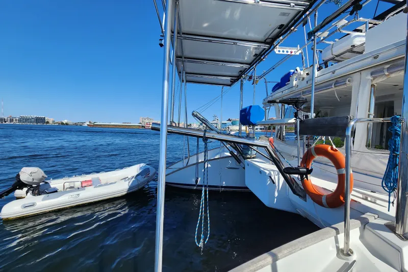 Slide: The Image of 2008 Lagoon 500 yacht with dinghy on calm water, featuring a lifebuoy and clear blue sky. - 23