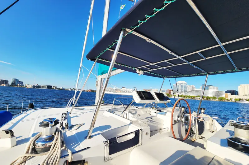 Slide: The Image of Lagoon 500 catamaran (2008) sailing near city skyline under clear blue sky. - 14
