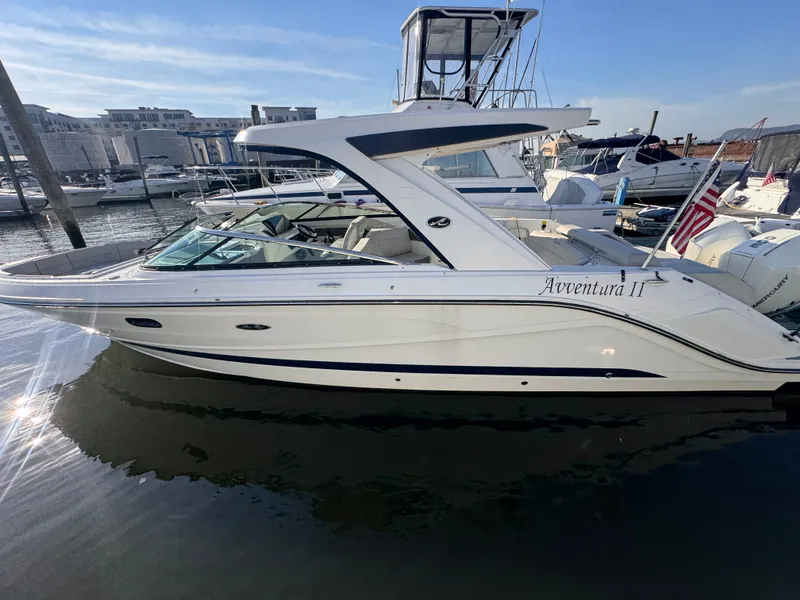 Slide: The Image of 2020 Sea Ray SLX 310 Outboard in a marina, featuring sleek design and spacious deck. - 2
