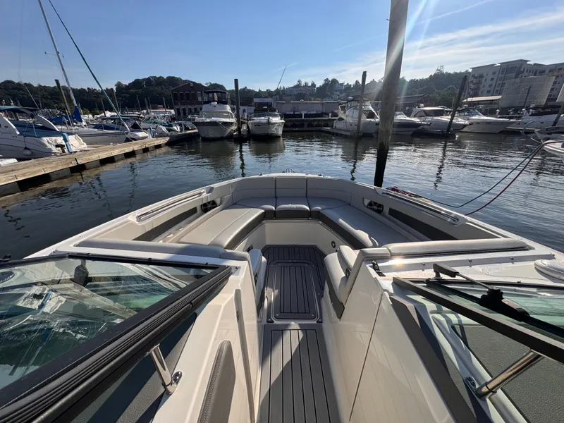 Slide: The Image of The image shows the bow of a 2020 Sea Ray SLX 310 Outboard in a marina. - 23