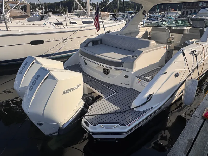 Slide: The Image of The image shows a 2020 Sea Ray SLX 310 Outboard boat docked in a marina. - 7