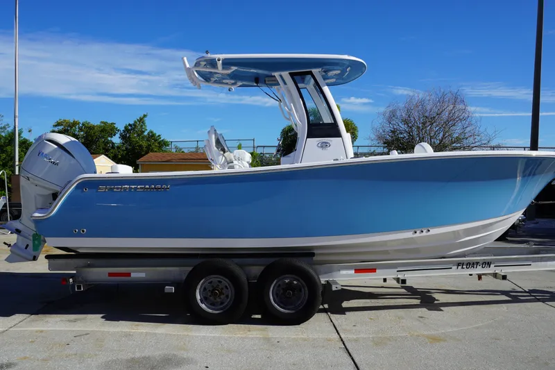 Slide: The Image of 2026 Sportsman Heritage 231 Center Console boat on trailer, blue hull, sunny day. - 1