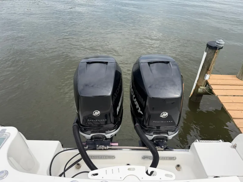 Slide: The Image of Two Mercury outboard engines are mounted on the stern of a Sailfish 290 CC boat docked. - 35