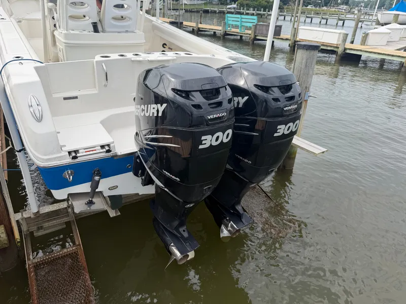 Slide: The Image of The image shows a 2014 Sailfish 290 CC boat with two Mercury 300 outboard engines. - 37