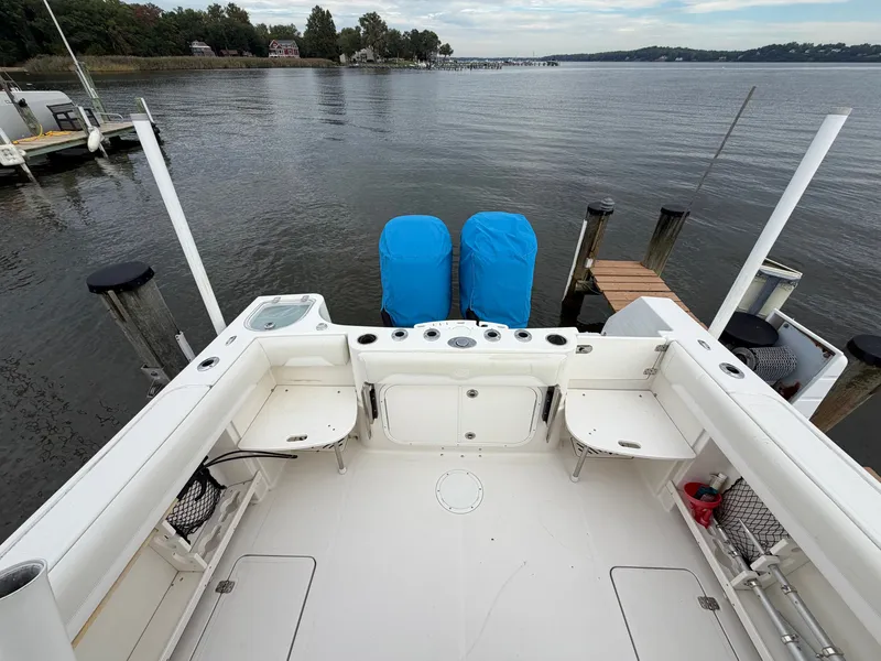 Slide: The Image of The image shows the cockpit of a 2014 Sailfish 290 CC boat docked at a calm waterway. - 23