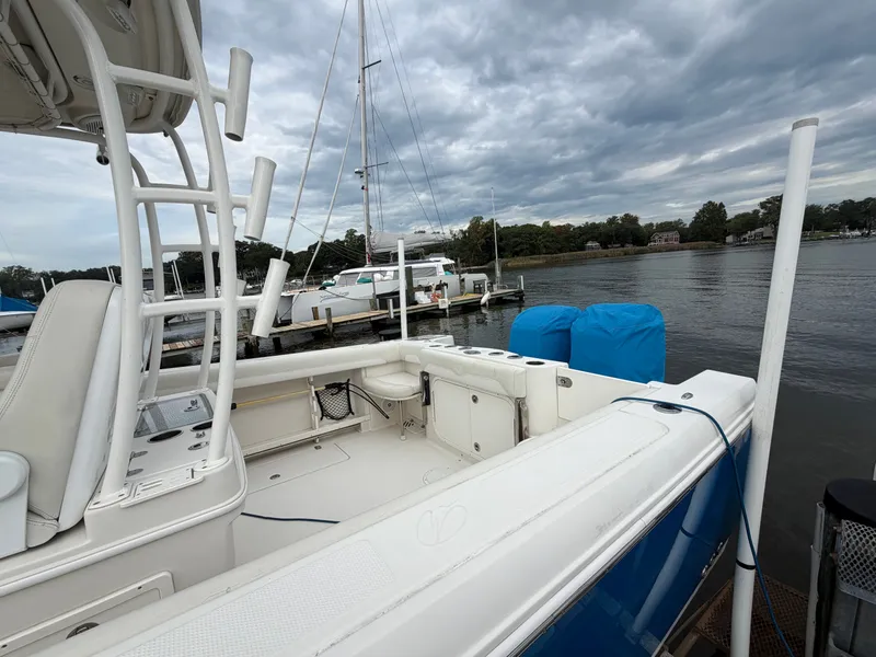 Slide: The Image of A 2014 Sailfish 290 CC docked at a calm pier under a cloudy sky. - 9