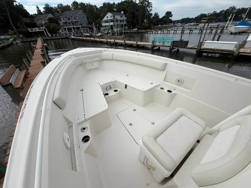 Slide: The Image of The image shows the deck of a 2014 Sailfish 290 CC boat with seating and storage. - 10