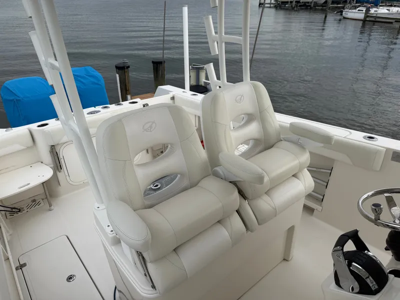 Slide: The Image of Two white captain's chairs on a boat overlooking the water. - 22