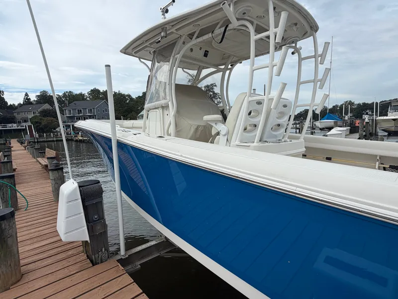 Slide: The Image of A blue and white 2014 Sailfish 290 CC docked at a wooden pier in a marina. - 8