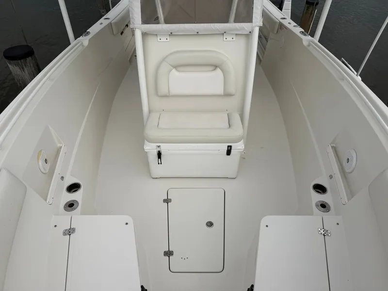 Slide: The Image of The image shows the cockpit of a 2014 Sailfish 290 CC with white seating and storage. - 14