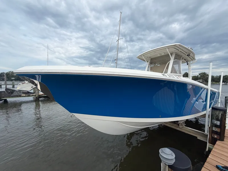 Slide: The Image of A blue and white 2014 Sailfish 290 CC is docked on the water. - 4