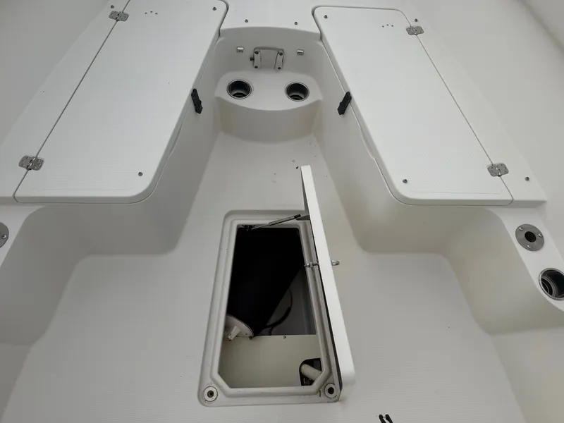 Slide: The Image of The image shows the deck of a 2014 Sailfish 290 CC with storage hatches and cup holders. - 15