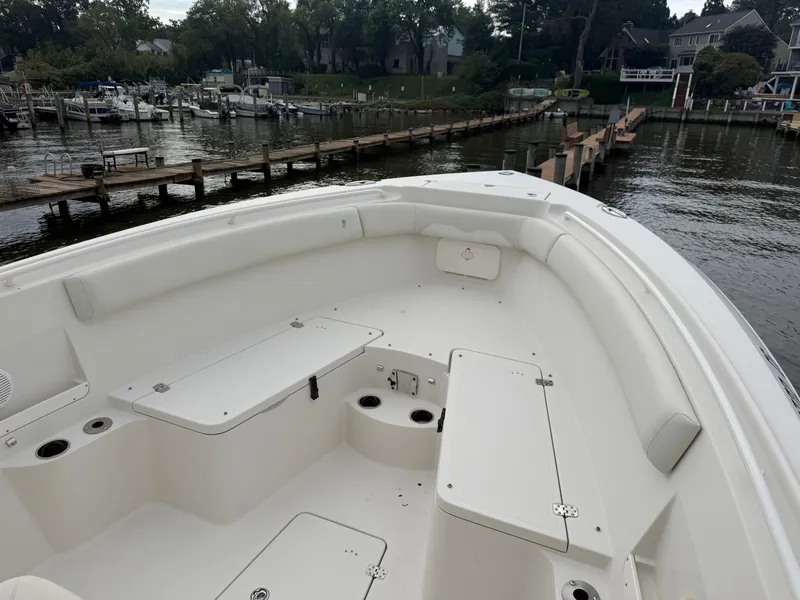 Slide: The Image of The image shows the bow area of a 2014 Sailfish 290 CC boat in a marina. - 12