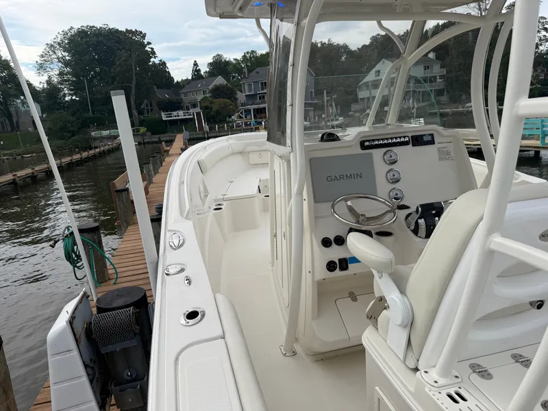 Slide: The Image of A 2014 Sailfish 290 CC docked. The cockpit features a Garmin navigation system. - 27