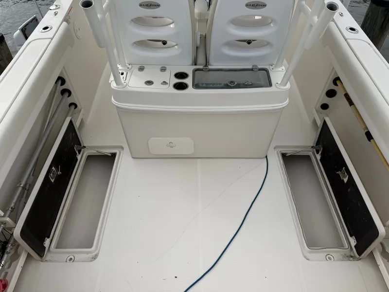 Slide: The Image of The image shows the cockpit of a 2014 Sailfish 290 CC with storage compartments and rod holders. - 33