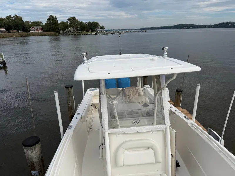 Slide: The Image of A 2014 Sailfish 290 CC docked at a calm pier with cloudy skies in the background. - 38