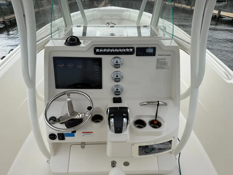 Slide: The Image of The image shows the helm of a 2014 Sailfish 290 CC with a steering wheel and instruments. - 20