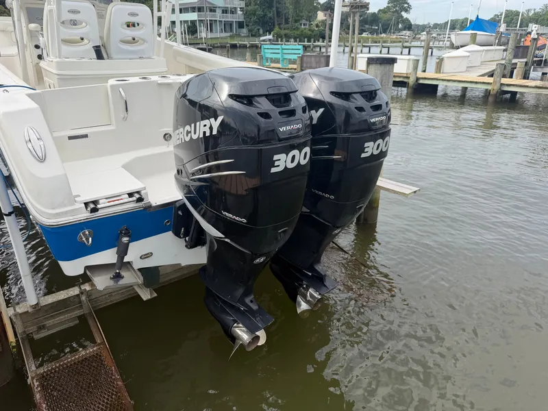 Slide: The Image of A 2014 Sailfish 290 CC with twin Mercury 300 outboard engines, docked at a calm marina. - 36