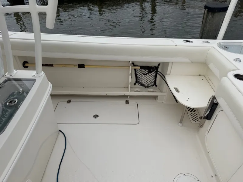 Slide: The Image of The image shows the cockpit of a 2014 Sailfish 290 CC with white interior and storage space. - 25