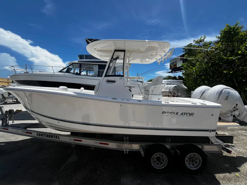 Slide: The Image of 2025 Regulator 23 boat on a trailer under a clear blue sky. - 5