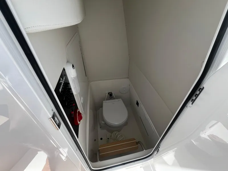 Slide: The Image of 2025 Regulator 23 boat interior bathroom with toilet and storage space. - 18